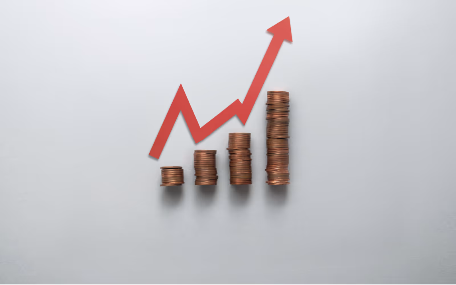 Stacked coins with an upward arrow representing loyalty app pricing tiers for UK small businesses.